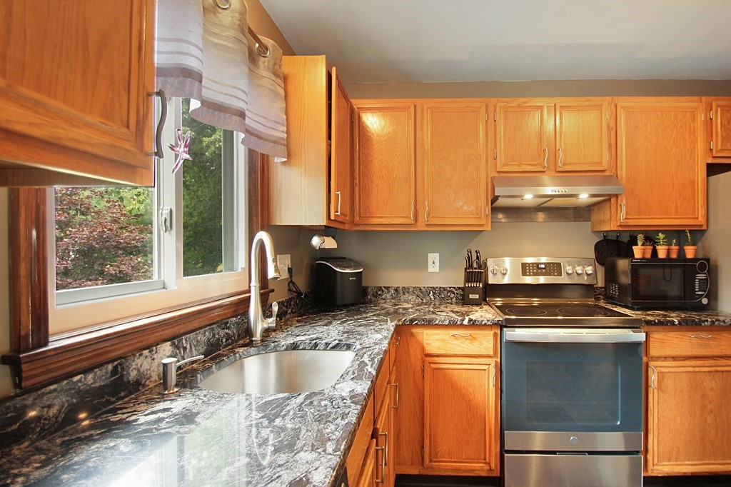 12 Indian Rock Road Haverhill, MA 01832 - Photo 7 of 31 a kitchen with granite countertop a stove and a sink