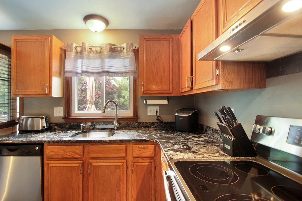 12 Indian Rock Road Haverhill, MA 01832 - Photo 8 of 31 a kitchen with granite countertop a stove sink and cabinets