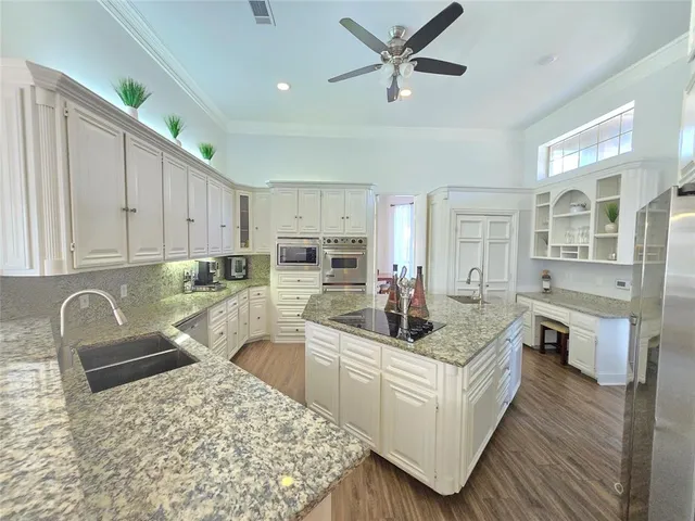 a kitchen with stainless steel appliances granite countertop a sink stove and refrigerator