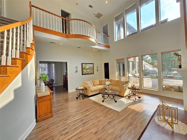 a living room with furniture stairs and a wooden floor