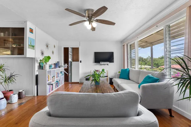 a living room with furniture floor to ceiling window and a flat screen tv