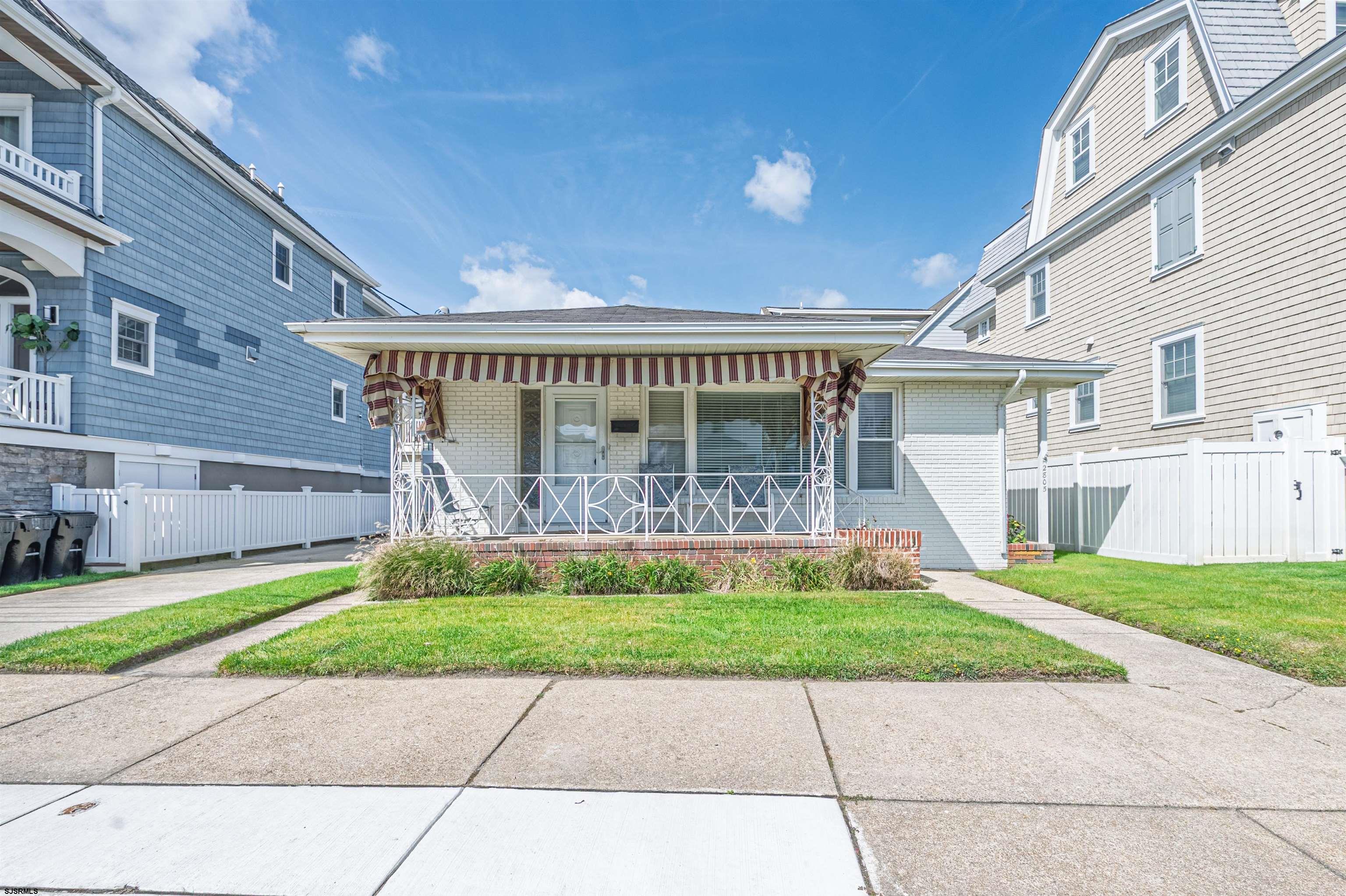 a view of a house with a yard and large tree