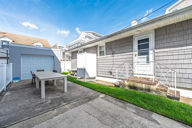 a backyard of a house with table and chairs