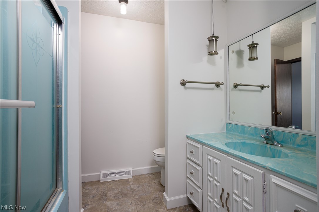 5680 Lance Road Medina, OH 44256 - Photo 26 of 32 Bathroom featuring toilet, a textured ceiling, tile floors, and vanity