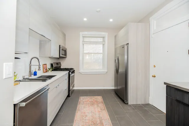 a kitchen with stainless steel appliances granite countertop a refrigerator and a sink