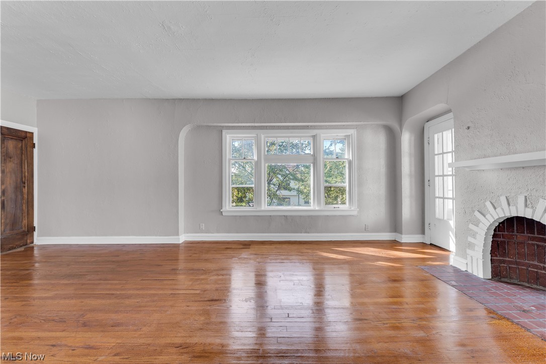 1499 Sherbrook Road South Euclid, OH 44121 - Photo 8 of 41 Unfurnished living room with a brick fireplace and wood-type flooring