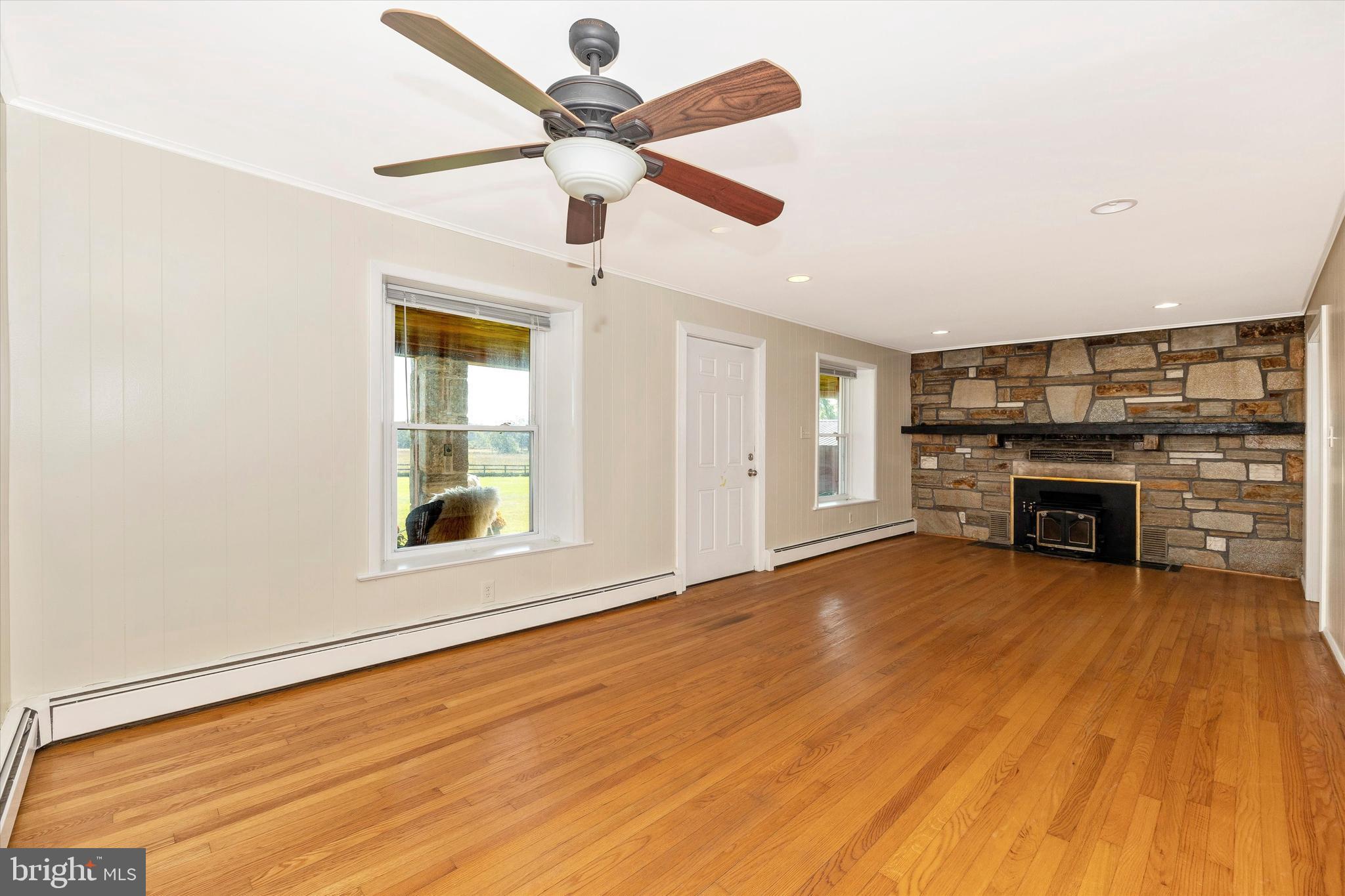 1021 Saffell Road Reisterstown, MD 21136 - Photo 28 of 57 an empty room with windows fireplace and a ceiling fan