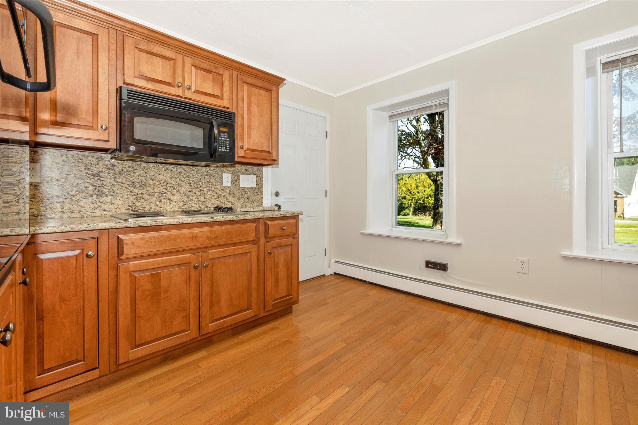 1021 Saffell Road Reisterstown, MD 21136 - Photo 36 of 57 a kitchen with stainless steel appliances granite countertop a sink a microwave cabinets and a wooden floor
