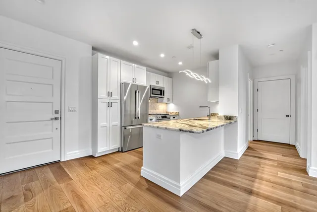 a kitchen with stainless steel appliances a refrigerator and a stove top oven