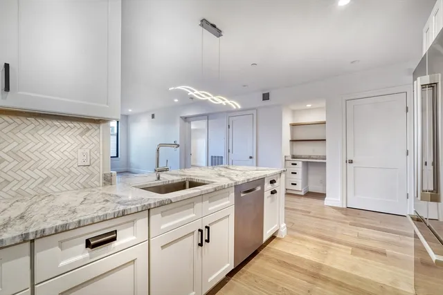 a kitchen with granite countertop a sink and cabinets