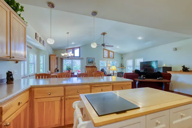 a kitchen with stainless steel appliances granite countertop a sink dishwasher a stove and a refrigerator with wooden floor