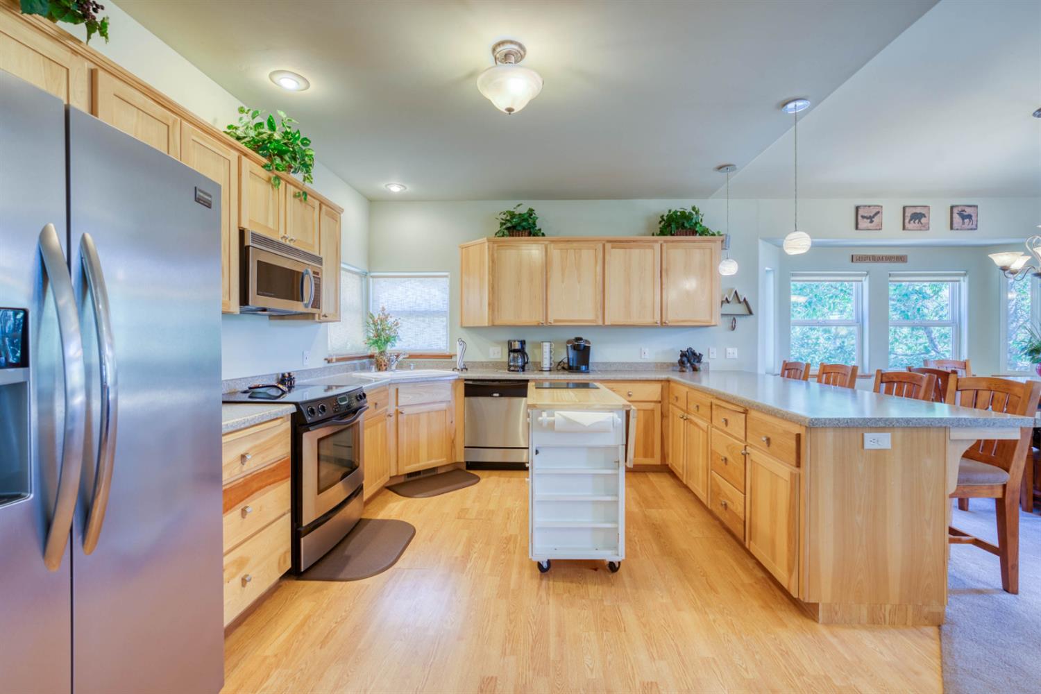 33855 Shaver Springs Road Auberry, CA 93602 - Photo 22 of 41 a kitchen with stainless steel appliances granite countertop a refrigerator a stove top oven a sink dishwasher and wooden cabinets with wooden floor