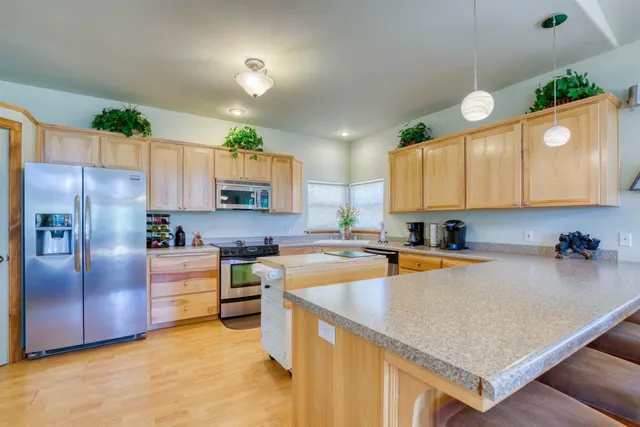 a kitchen with a refrigerator a stove a sink a counter top space and cabinets