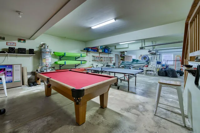 a room with pool table and windows