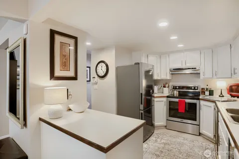 a kitchen with stainless steel appliances granite countertop a refrigerator sink and stove