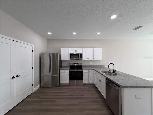 a kitchen with stainless steel appliances granite countertop a refrigerator and a sink