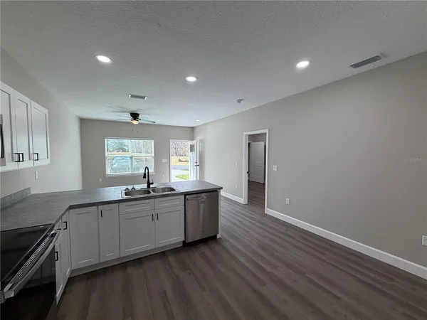 a large kitchen with lot of wooden cabinets a sink and dishwasher