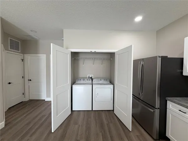 a kitchen with a refrigerator a sink and wooden floor