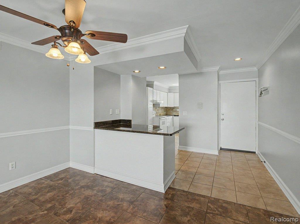 1974 Klingensmith Road, Unit 4 Bloomfield Hills, MI 48302 - Photo 7 of 35 Dining area featuring a ceiling fan with integrated lighting, crown molding, and wainscoting