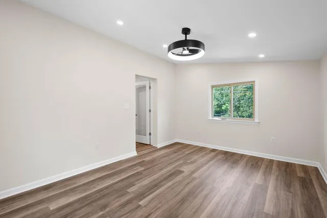 an empty room with a window and a fan