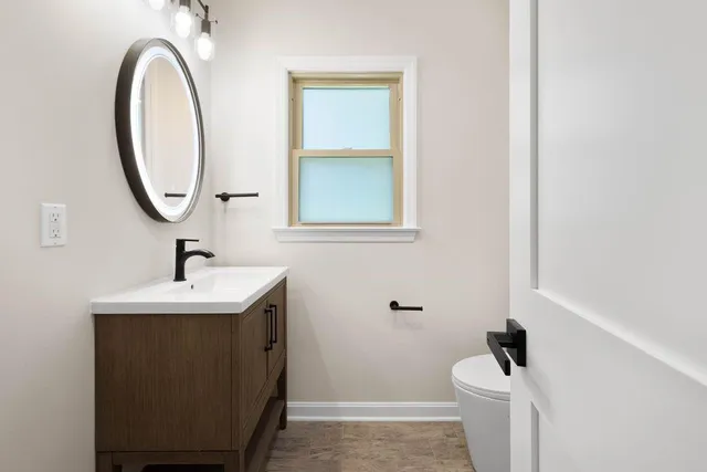 a bathroom with a sink a toilet and a mirror