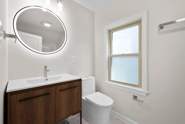 a bathroom with a toilet a sink and a mirror