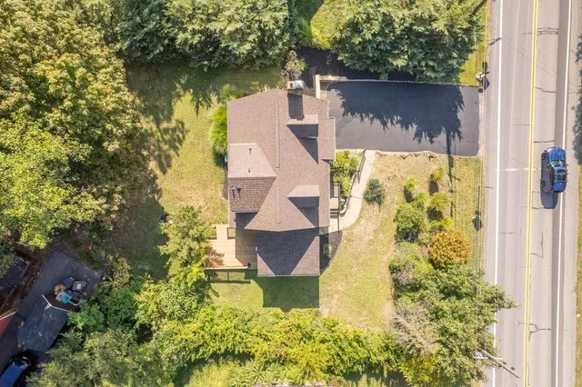an aerial view of residential house with outdoor space and trees all around