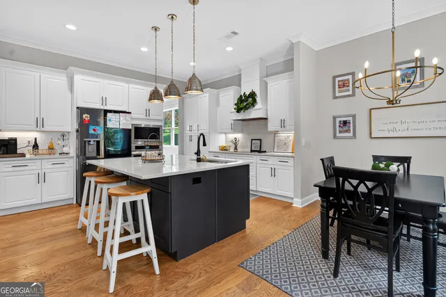 a kitchen with kitchen island a dining table and chairs
