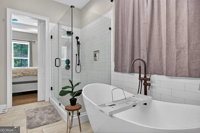 a bathroom with a sink a faucet a potted plant and a shower