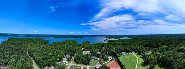 an aerial view of a house with a yard and lake view