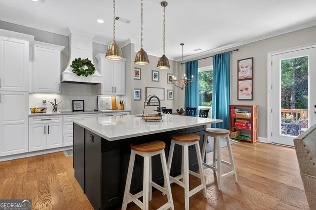 a kitchen with granite countertop a sink cabinets and wooden floor