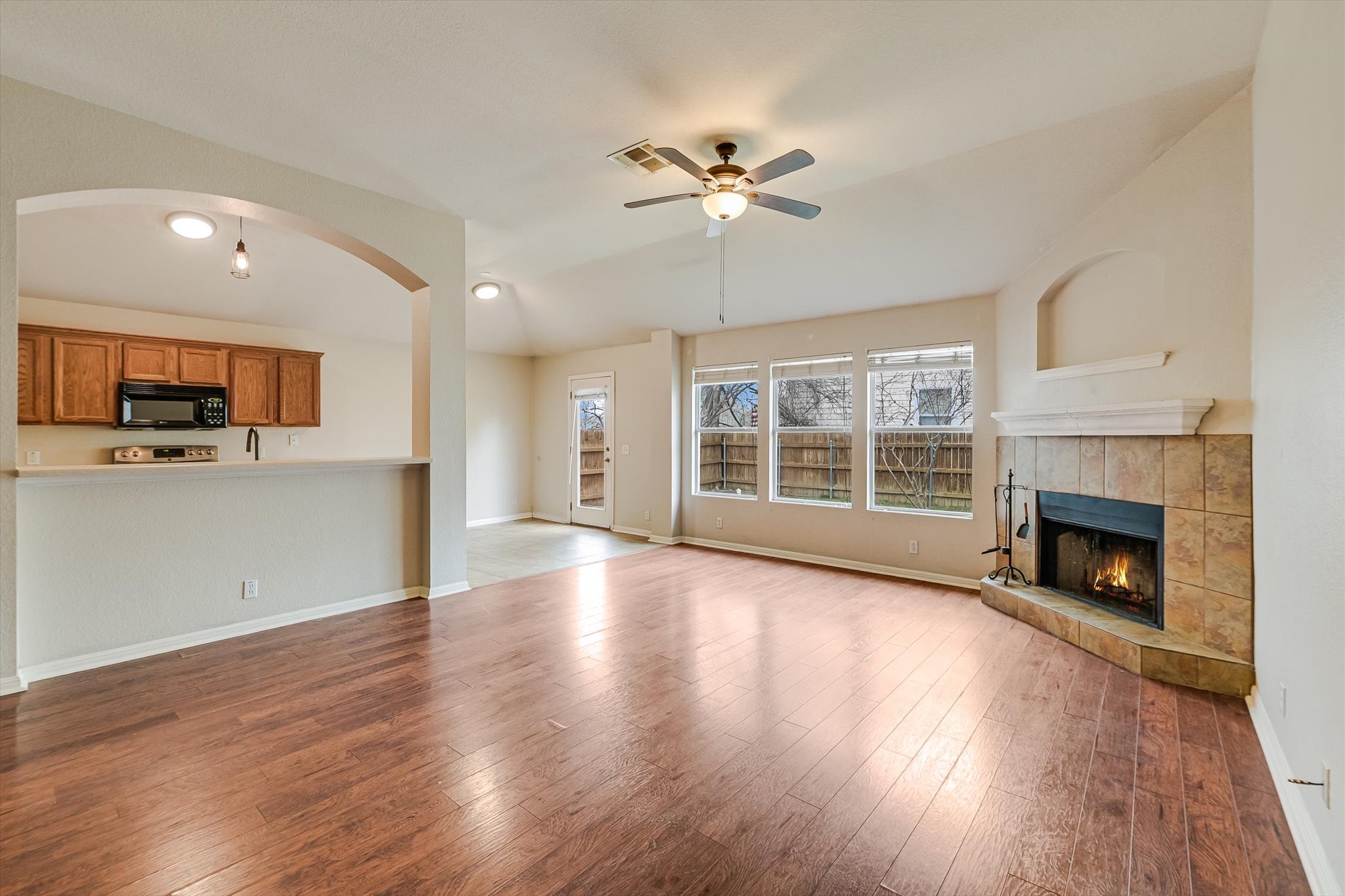 9616 Magna Carta Loop Austin, TX 78754 - Photo 12 of 28 a view of an empty room with wooden floor and a kitchen