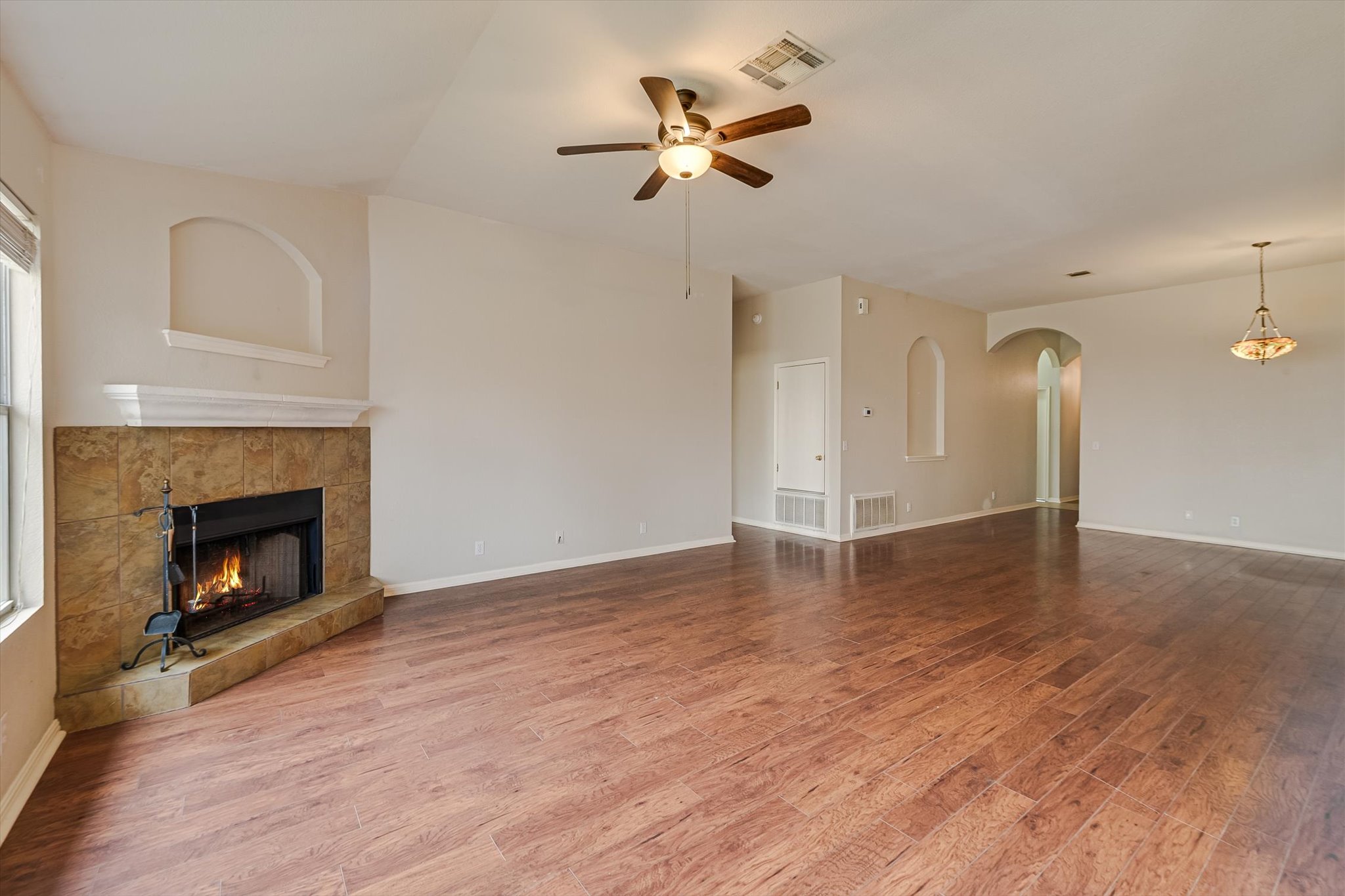 9616 Magna Carta Loop Austin, TX 78754 - Photo 13 of 28 a view of a livingroom with a fireplace a ceiling fan and wooden floor