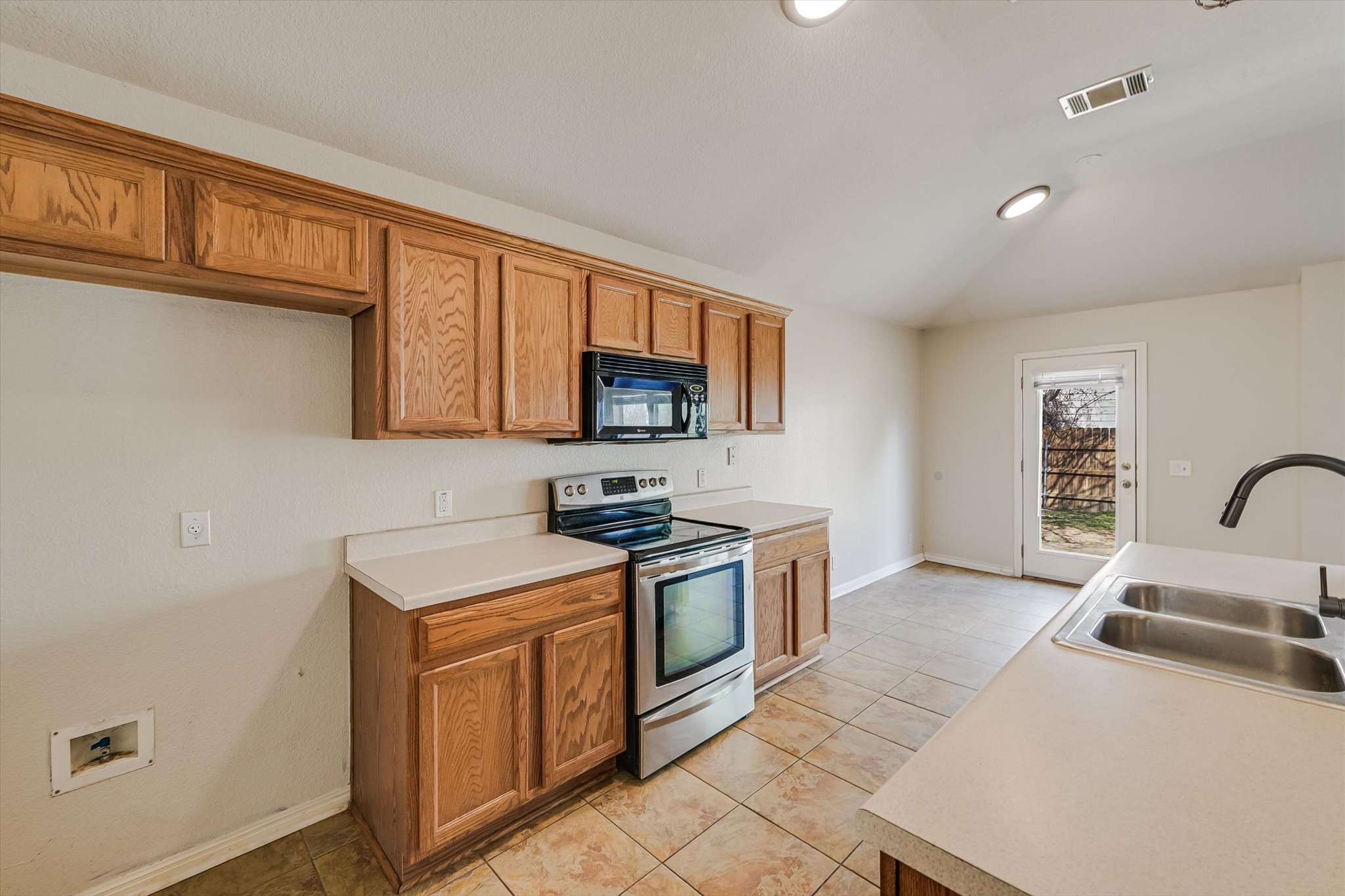 9616 Magna Carta Loop Austin, TX 78754 - Photo 17 of 28 a kitchen with stainless steel appliances granite countertop a sink stove and microwave