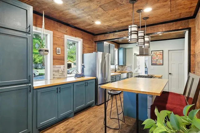 a kitchen with stainless steel appliances granite countertop a sink refrigerator and a window