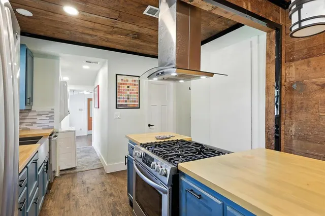 a kitchen with a stove and a wooden floor