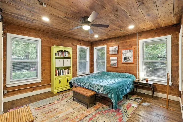 a bed sitting in a spacious bedroom next to a window
