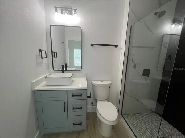 a bathroom with a sink toilet and mirror