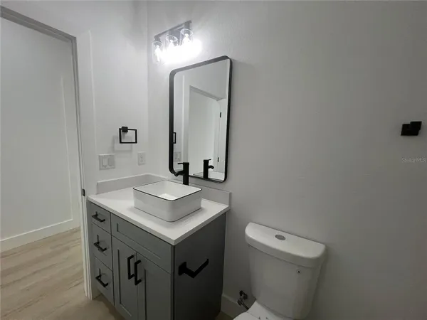 a bathroom with a sink toilet and mirror