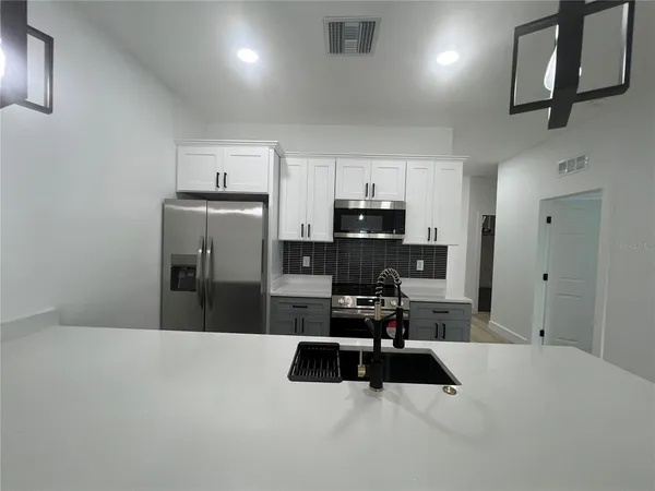 a kitchen with stainless steel appliances a refrigerator and a sink