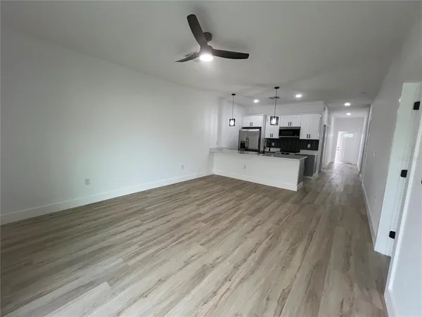 a view of a kitchen with a sink and wooden floor