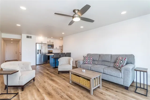 a living room with furniture kitchen view and a chandelier