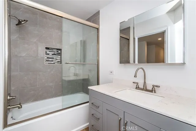 a bathroom with a shower sink and mirror