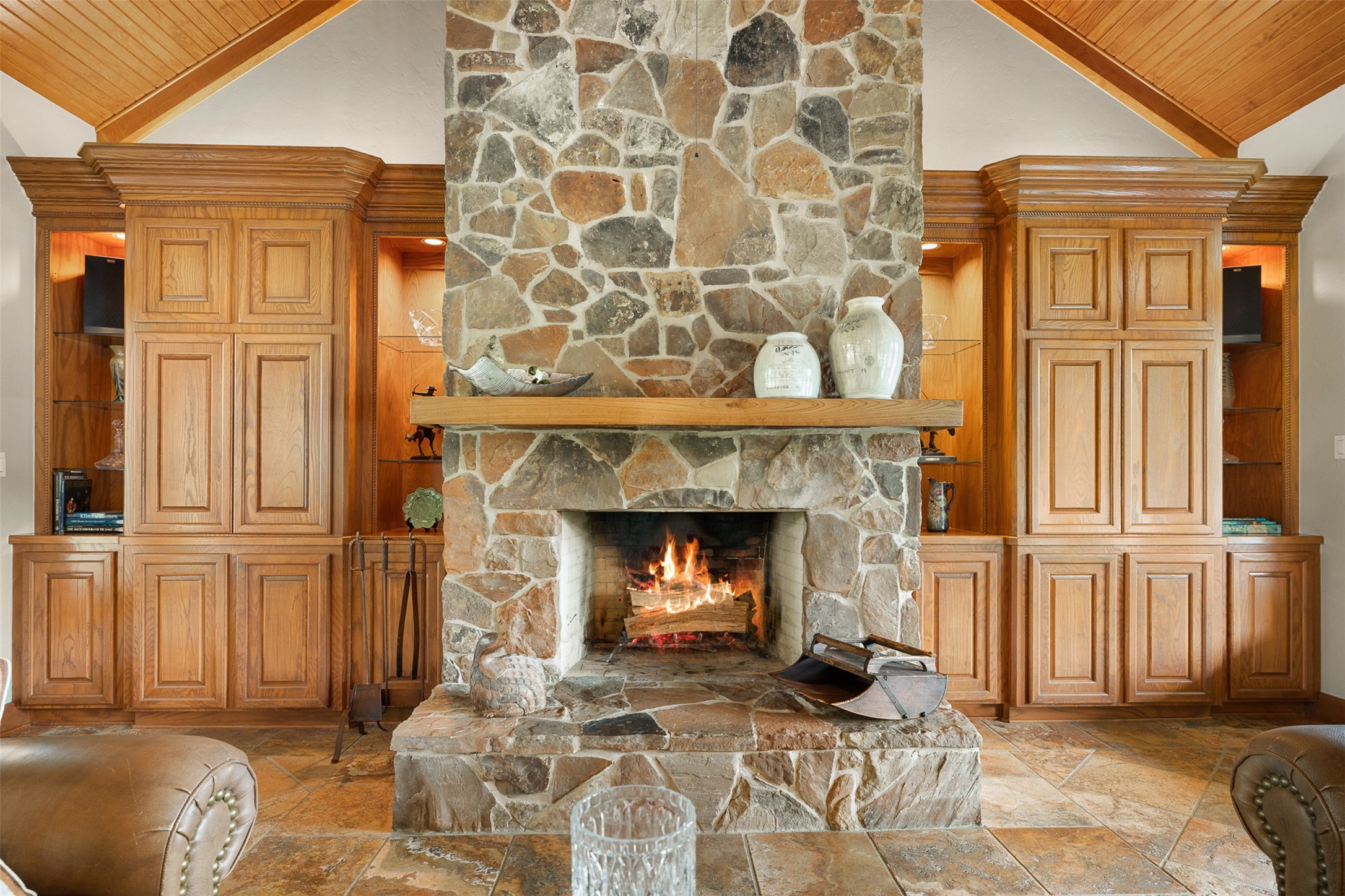 8502 Stansberry Road Wallis, TX 77485 - Photo 19 of 50 Gorgeous stone fireplace with a rustic wood mantle, flanked by elegant built-in wooden cabinets, creating a warm and inviting focal point in the living area.