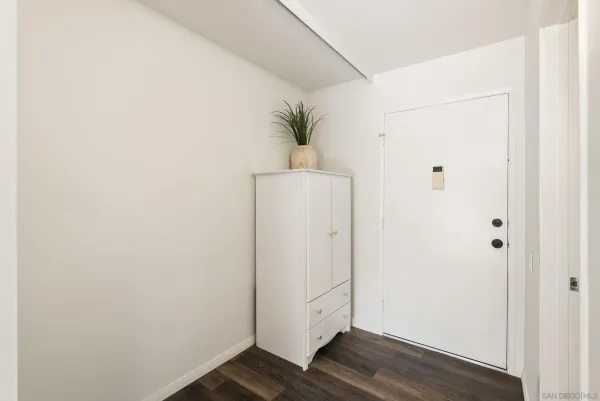 a view of a hallway with wooden floor and closet