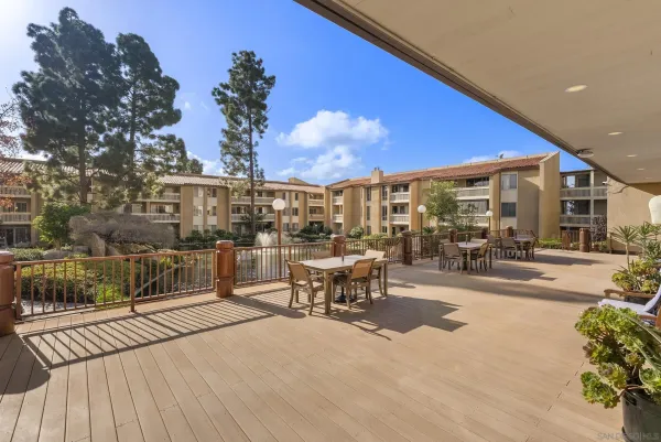 a view of a patio with dining table and chairs with wooden floor and fence