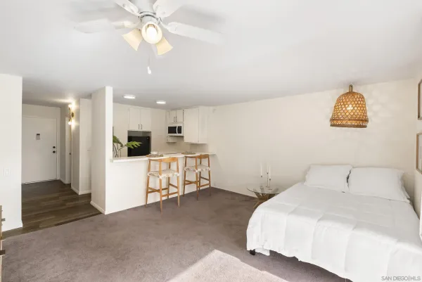 a spacious bedroom with a bed and a painting on the wall