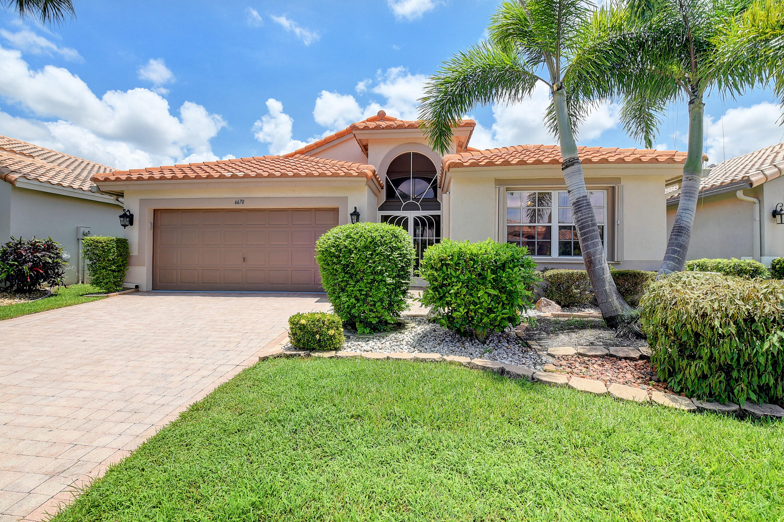 6670 Maybrook Road Boynton Beach, FL 33437 - Photo 25 of 72 a front view of a house with a garden