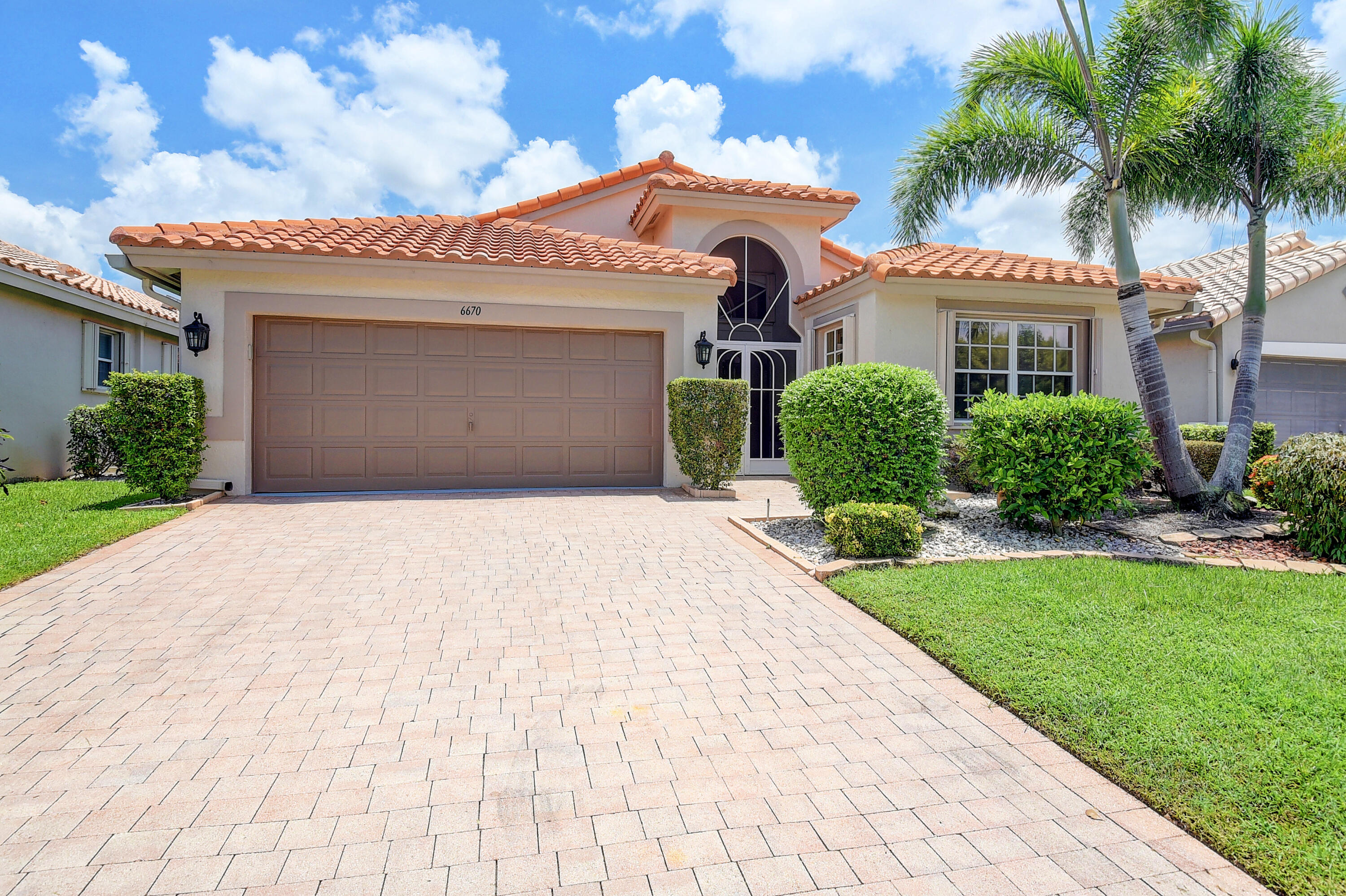 6670 Maybrook Road Boynton Beach, FL 33437 - Photo 26 of 72 a front view of a house with a yard and a garage