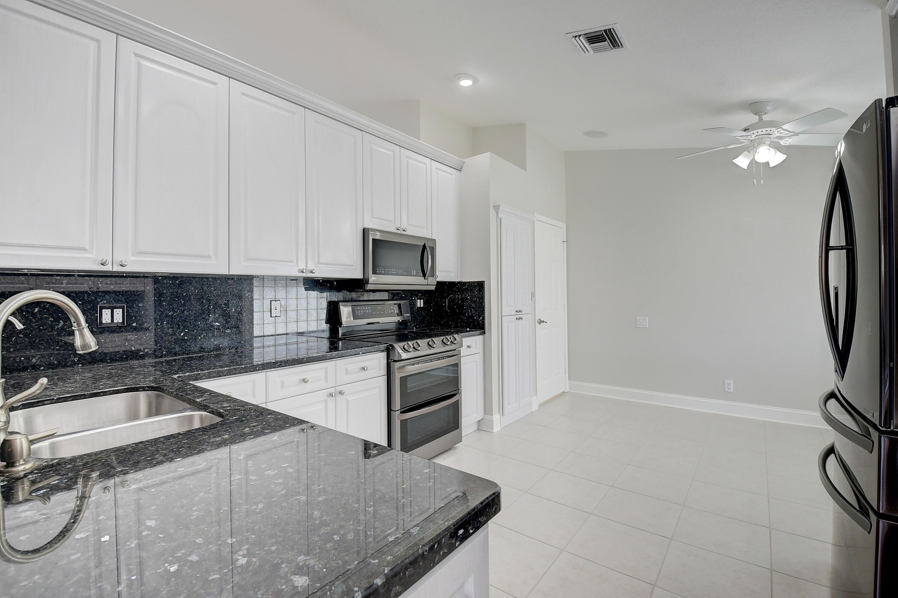 6670 Maybrook Road Boynton Beach, FL 33437 - Photo 3 of 72 a kitchen with a sink a stove and cabinets
